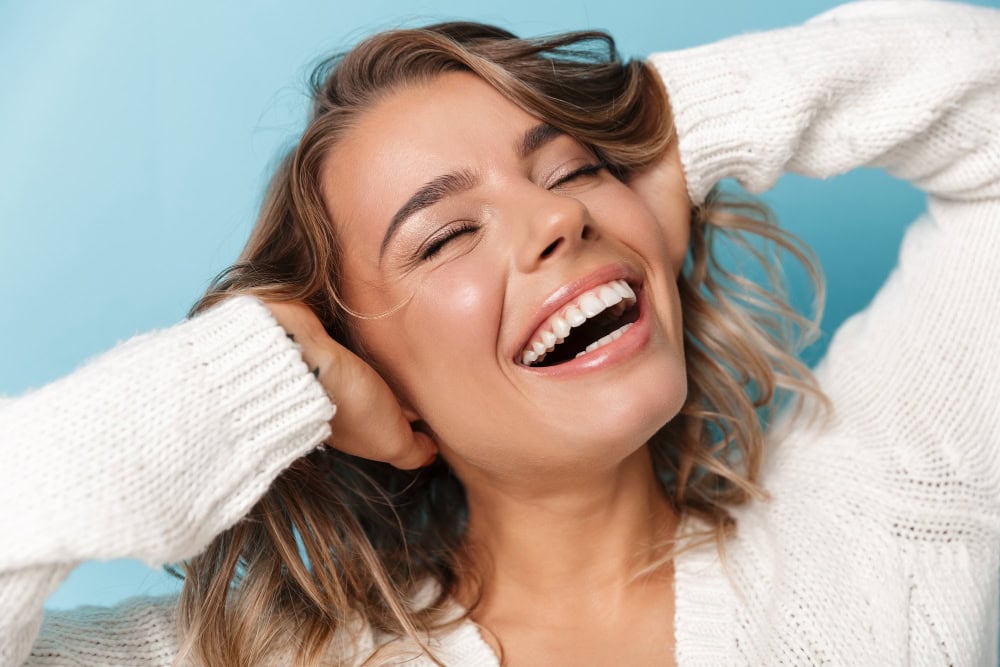 Mujer sonriendo con naturalidad tras su tratamiento de estética dental en Bueu.